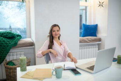 Positive happy businesswoman sitting in her office